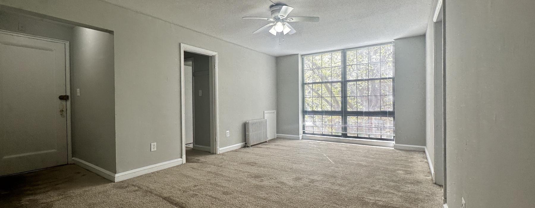 a room with a ceiling fan and a window