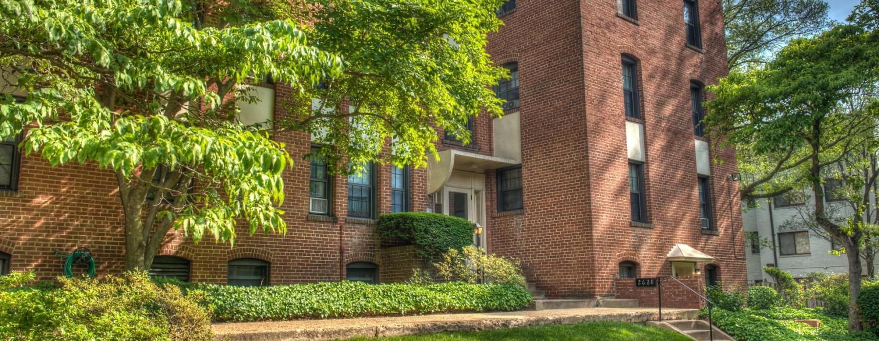 a brick building with a green lawn